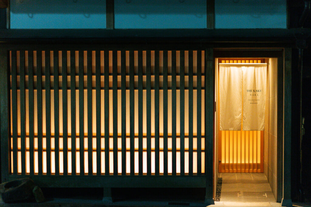 The lit entrance of THE KAKU at night in Naramachi, Nara